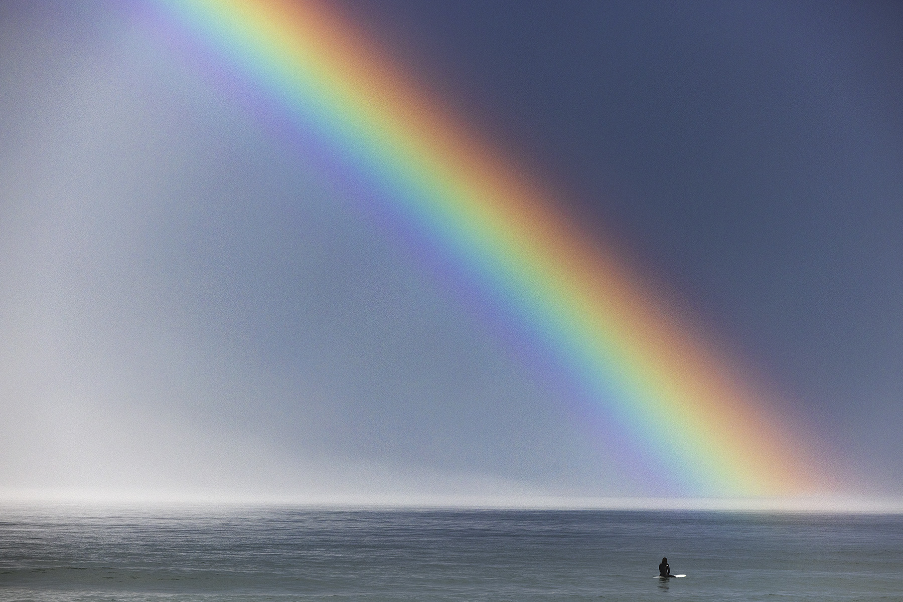 Rainbow surfer by New Hampshire based commercial outdoor lifestyle photographer Brian Nevins